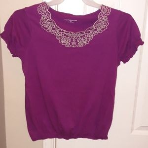 Purple top with floral embellishment